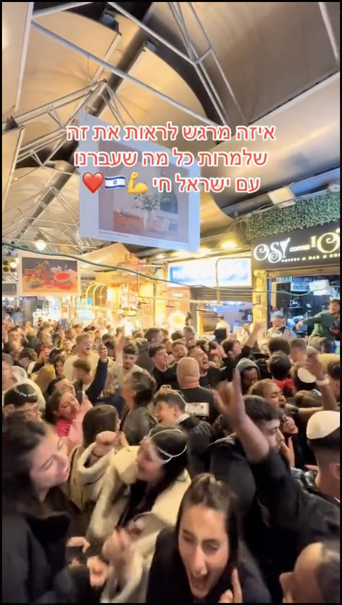 Un grand groupe de Juifs lors d'une fête de Pourim au marché Mahane Yehuda ont chanté ensemble Am Yisrael Chai