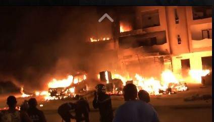 Un enfant s'accroche au balcon d'un immeuble en feu