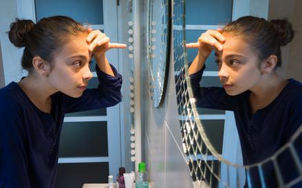 Adolescente se regardant dans le miroir©