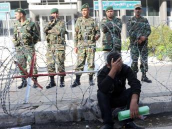 Un chômeur de Gafsa assis devant les bureaux de la CGP (Compagnie générale des phosphates) à Tunis gardée par des soldats le 30 novembre 2011. AFP/ FETHI BELAID