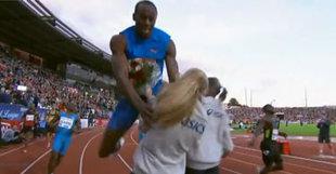 Usain Bolt a dû mal à s'arrêter après un 100 mètres, même lorsqu'une jeune femme lui tend un bouquet de fleur.