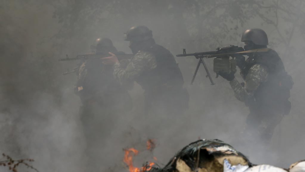 Des éléments des forces de sécurité ukrainiennes passent un barrage abandonné par les séparatistes pro-Russes à Slaviansk, le 24 avril.