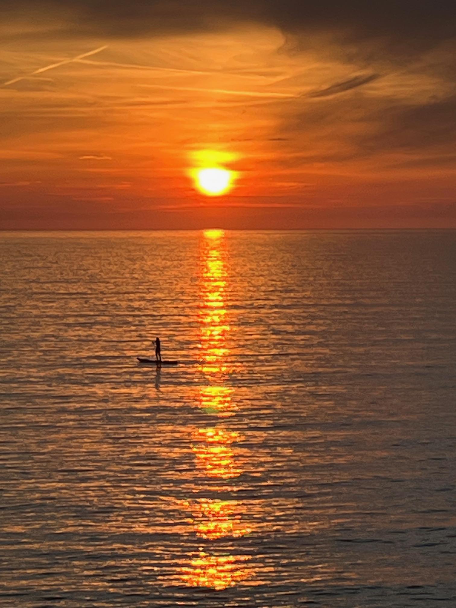 En paddle devant le coucher de soleil