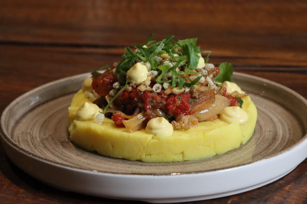 Causa limeña vegetal con cebolletas asadas, tomate concassé, piñones y mayonesa de ají