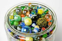 Según los responsables de esta investigación, la estructura atómica de los vidrios metálicos se asemeja al ordenamiento de estas canicas de diferentes tamaños en un frasco. Imagen: marionbirdy / Fotolia.