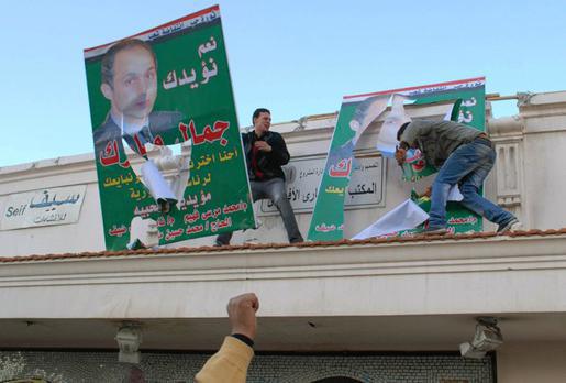 Des manifestants égyptiens déchirant des affiches de Gamal Moubarak, le fils du président égyptien Hosni Moubarak, Alexandrie le 25 janvier 2011 — AFP/Getty Images