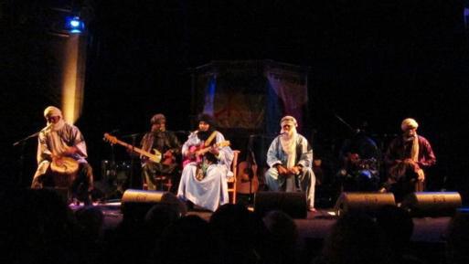 TINARIWEN avec en arrière plan les drapeaux Azawadien et Amazigh. Londres, le 29.11.12.PH/DR (Archives)