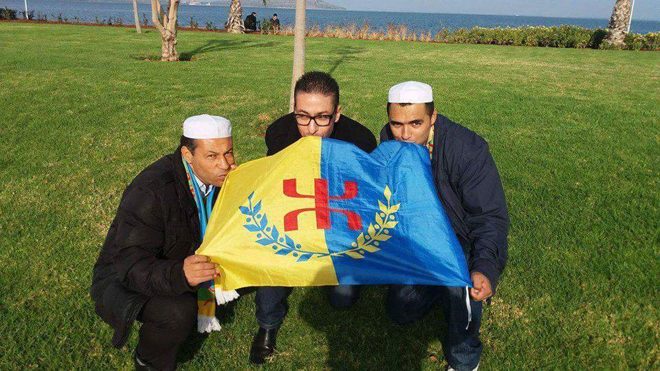Les mozabites Khodir Sekkouti (Porte-parole du MAM) et Salah Abbouna autour du rifain Rachid Zannay, embrassant le drapeau kabyle à Nador, Maroc, le 23/12/2015 (PH/DR)