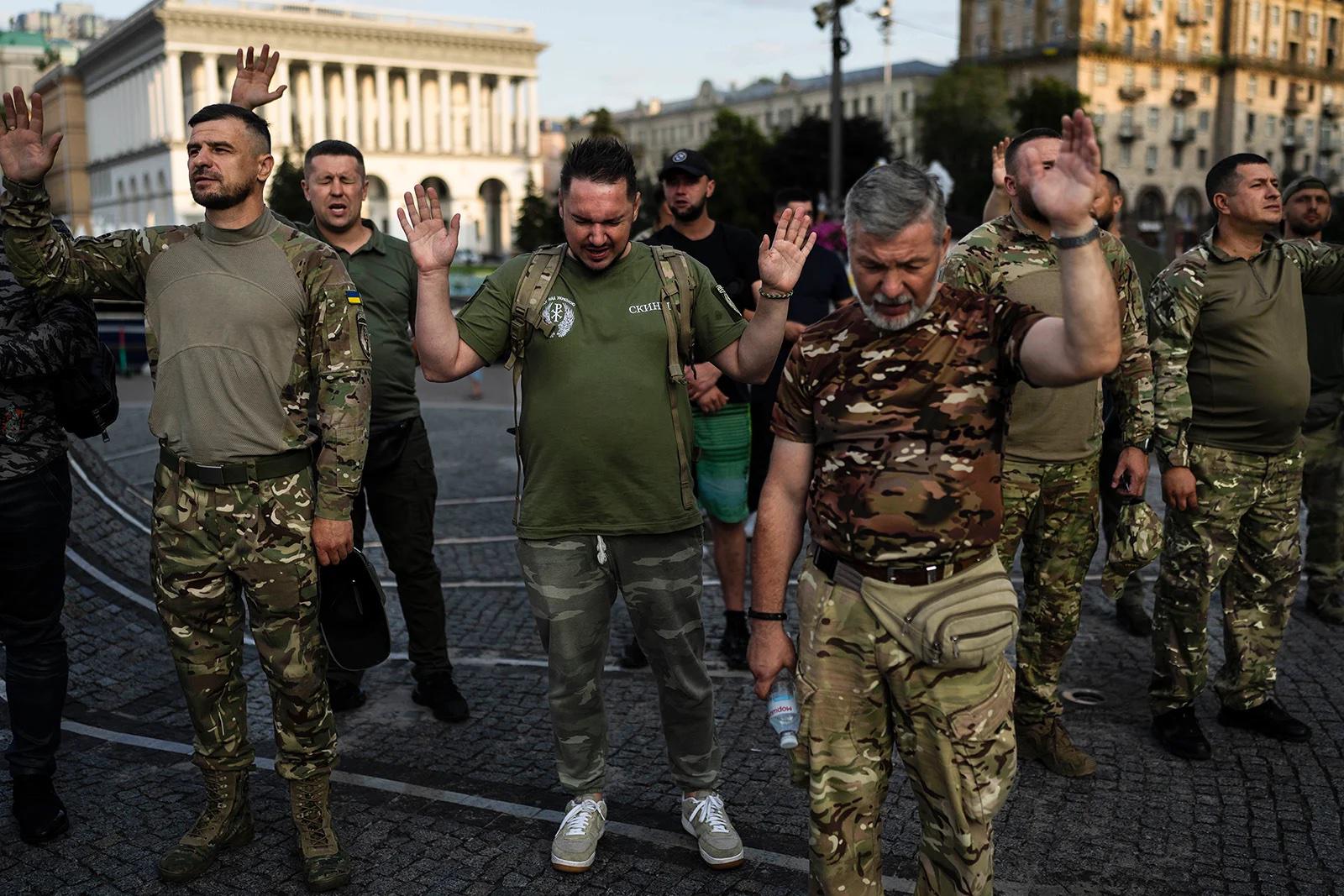 Un groupe de militaires ukrainiens prie lors d’un culte organisé par une église chrétienne locale à Kiev