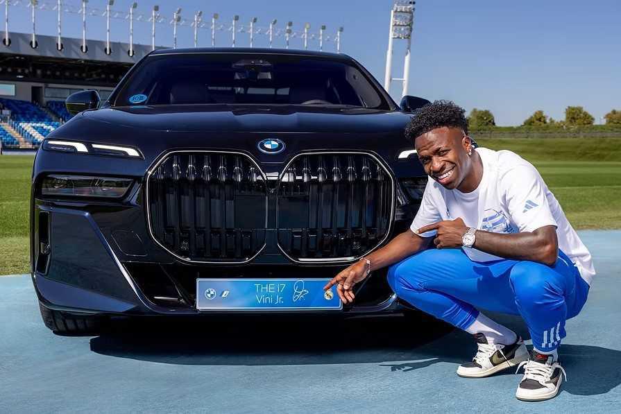 El primer equipo del Real Madrid posa junto a sus nuevos BMW