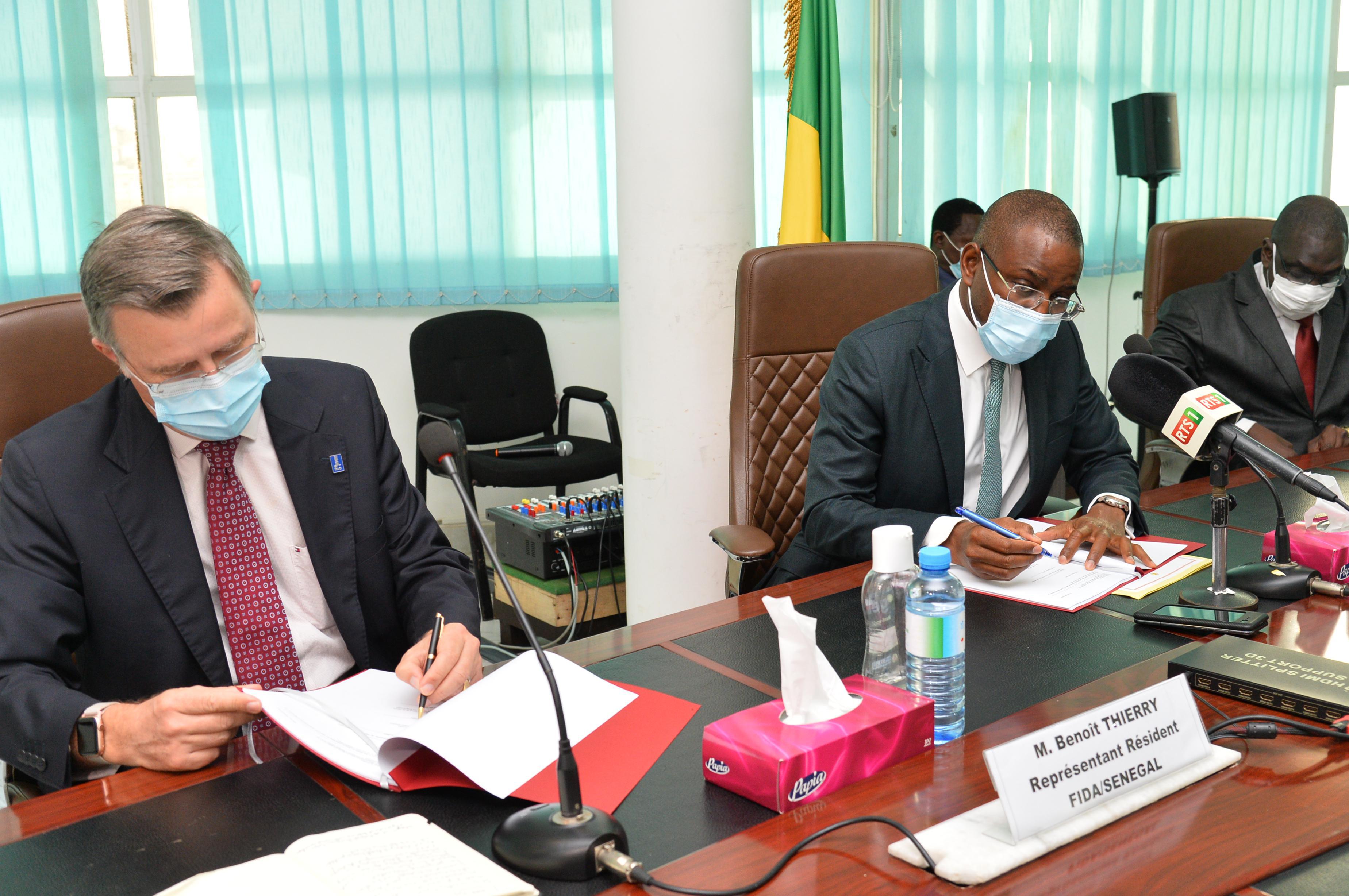 Signature d'une convention de financement du programme conjoint sahel entre Amadou Hott, ministre sénégalais de l’Economie, du Plan et de la Coopération et Benoit Thierry, représentant du Fonds international de développement agricole (Fida) 