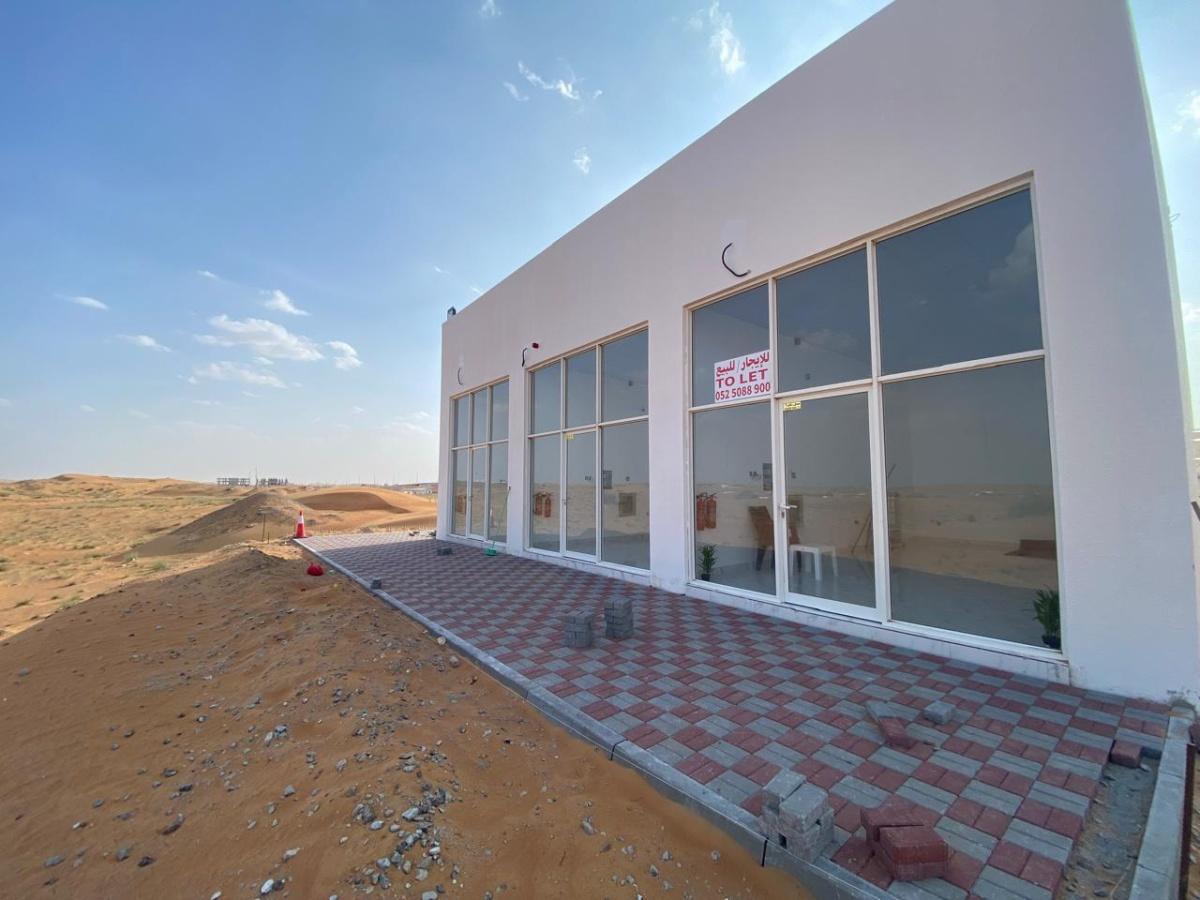 عندي ارض تجارية وعليها 3 محلات في الصناعية الجديدة قريب دبي للبيع