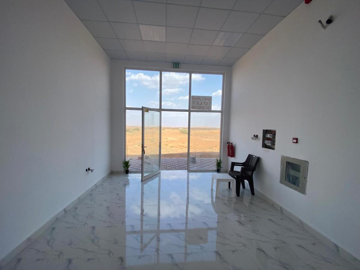 عندي ارض تجارية وعليها 3 محلات في الصناعية الجديدة قريب دبي للبيع