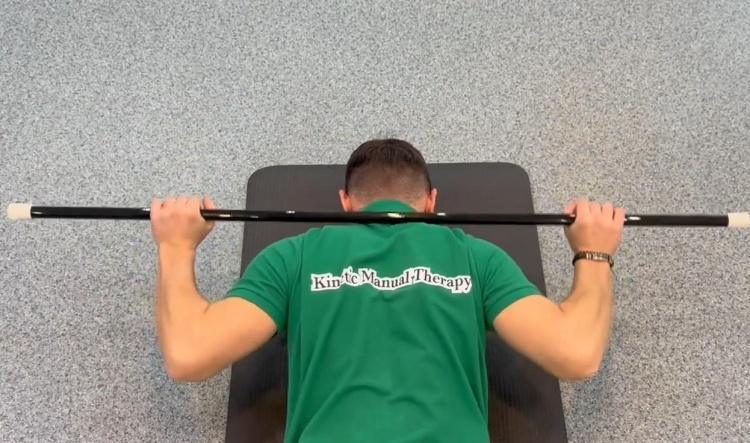 #18 Băț – tragem după cap (Prone stick pull behind the head)