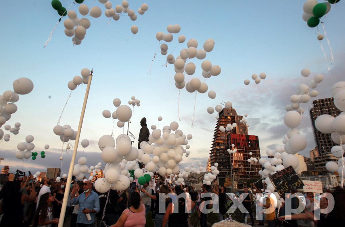 Anti-government protestors release balloons depicting the names of victims of Beirut blast