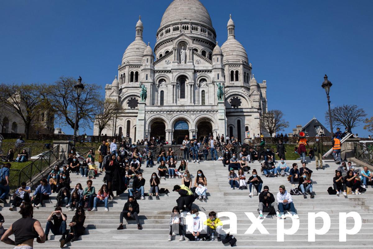 Parisians enjoy the good weather on the stairs of the Sacre Coeur Basilica