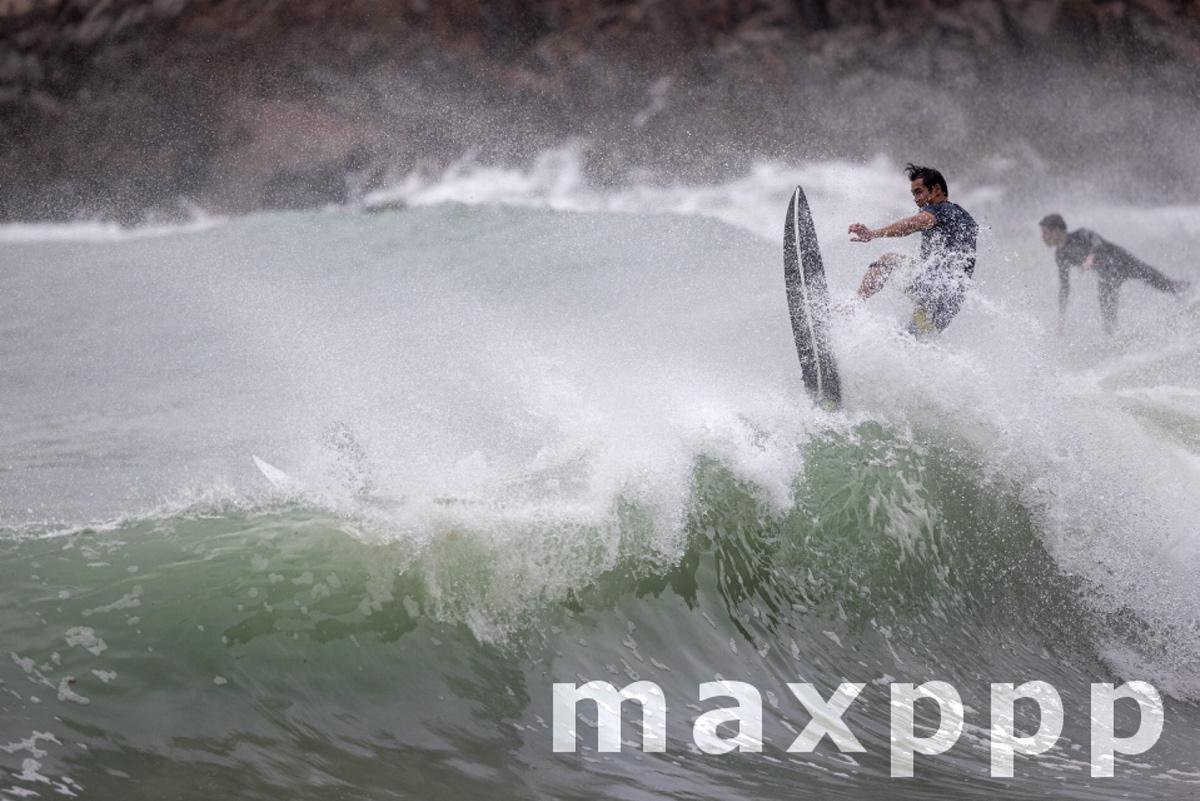 People surfing on waves brought by nearby typhoon Nesat