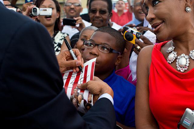 Le président Barack Obama, signant un autographe, sur le tarmac de l'aéroport Louis Armstrong, à la Nouvelle-Orléans, en juillet 2012. (Photo : © Official White House / Pete Souza)
