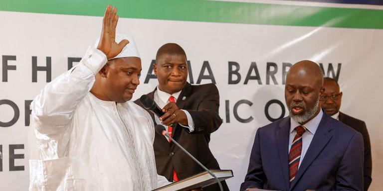 Le président gambien Adama Barrow jurant sur le Coran lors de son investiture au Sénégal.