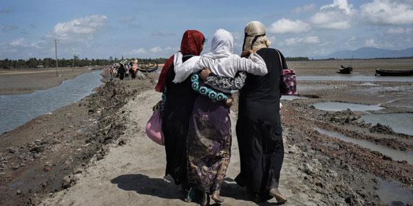 Trois femmes rohingyas ayant fui la Birmanie en traversant la rivière Naf marchent vers un camp de réfugiés situé à Teknaf, dans le district de Cox's Bazar, au Bangladesh. ©Anastasia Taylor-Lind/HRW