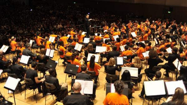 Aimer la musique classique et grandir en banlieue n’est pas antinomique ! Par exemple, Démos (Dispositif d’éducation musicale et orchestrale à vocation sociale), une initiative lancée en 2010 en Île-de-France, initie les enfants des quartiers populaires à la musique classique. Âgés entre 7 et 14 ans, les jeunes sont encadrés par des musiciens de l’Orchestre de Paris et de l’orchestre Divertimento, dirigé par Zahia Ziouani.