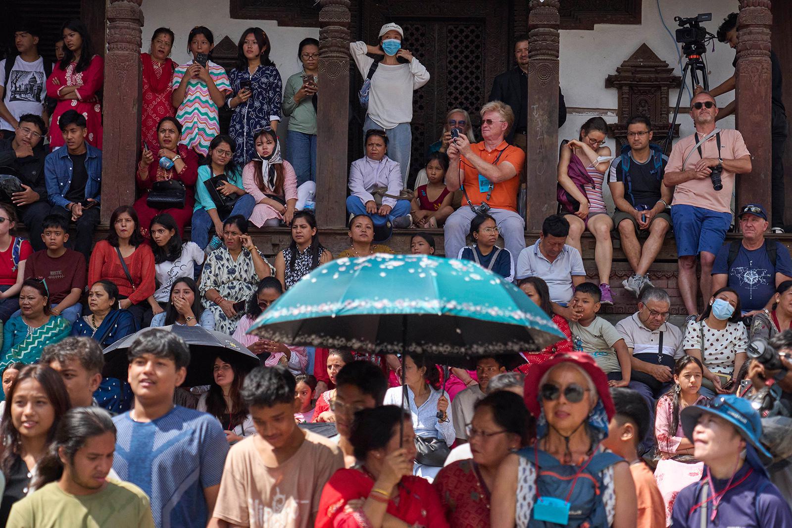 نيباليون وسياح يتابعون الموكب الذي تنقل فيه الإلهة الحيّة الجديدة في نيبال، كوماري أرياتارا شاكيا، إلى قصر المعبد "كوماري غار" حيث Il s'agit du 30 janvier 2025. (صورة لوكالة أسوشيتد برس/نيرنجان شريستا)