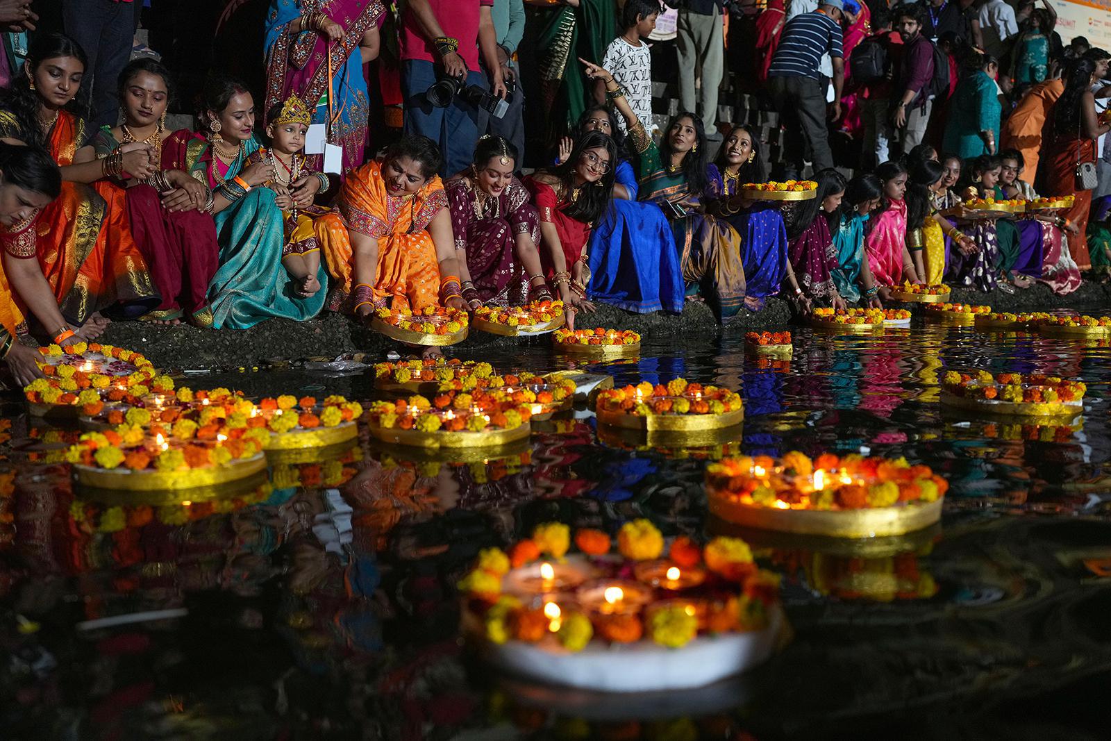 نساء هندوسيات يشعلن مصابيح زيتية عند بركة بانغانغا خلال احتفال ديف ديبافالي في مومباي، الهند، يوم الأربعاء