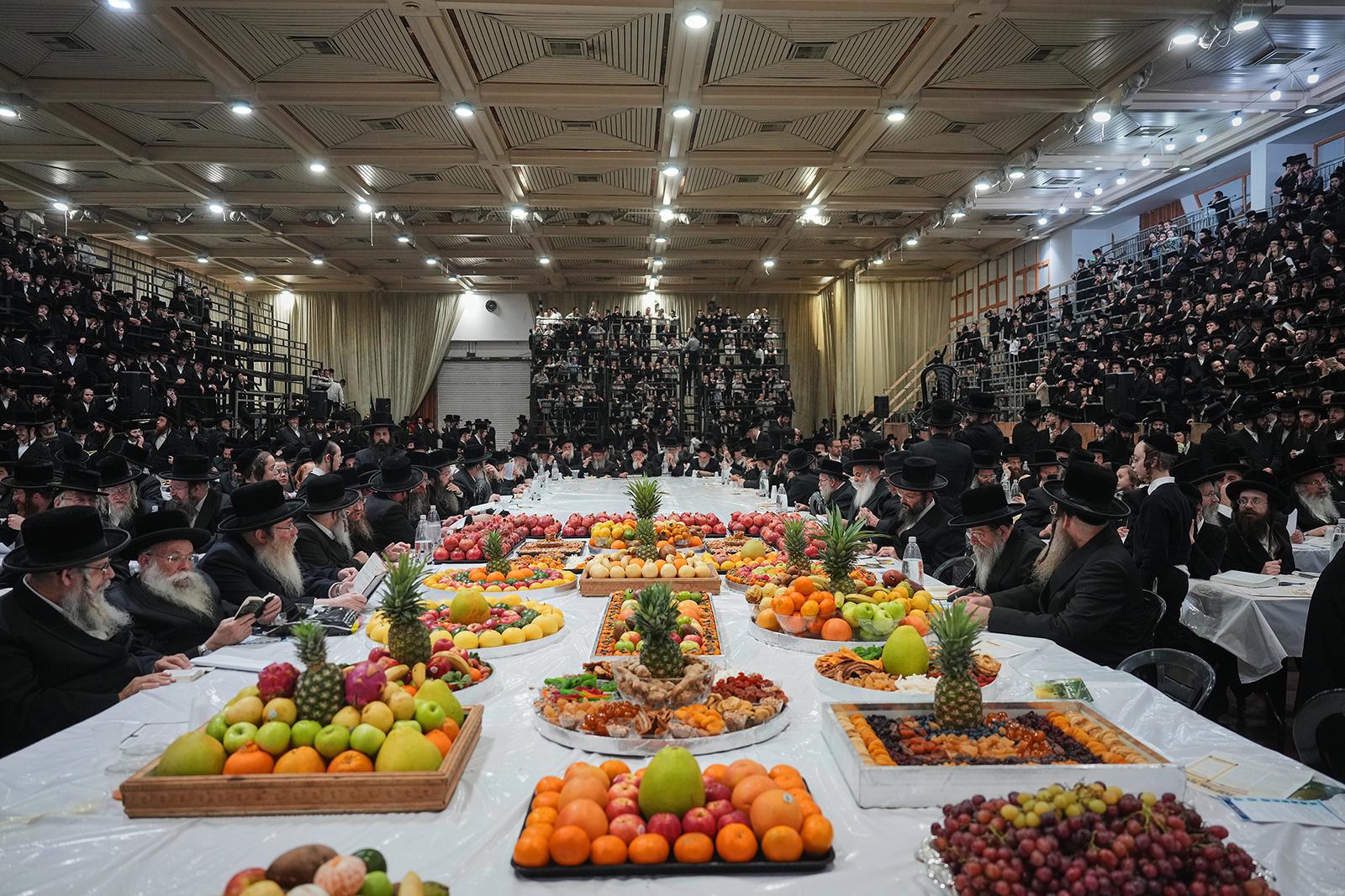 يجتمع يهود متشددون من سلالة سانز الحسيدية حول مائدة طويلة مليئة بالفاكهة للاحتفال بعيد تو بشفاط اليهودي، "رأس السنة للأشجار"، في نتانيا، إسرائيل، يوم الاثنين 2 فبراير 2026. (صورة AP/أرييل شاليت) 