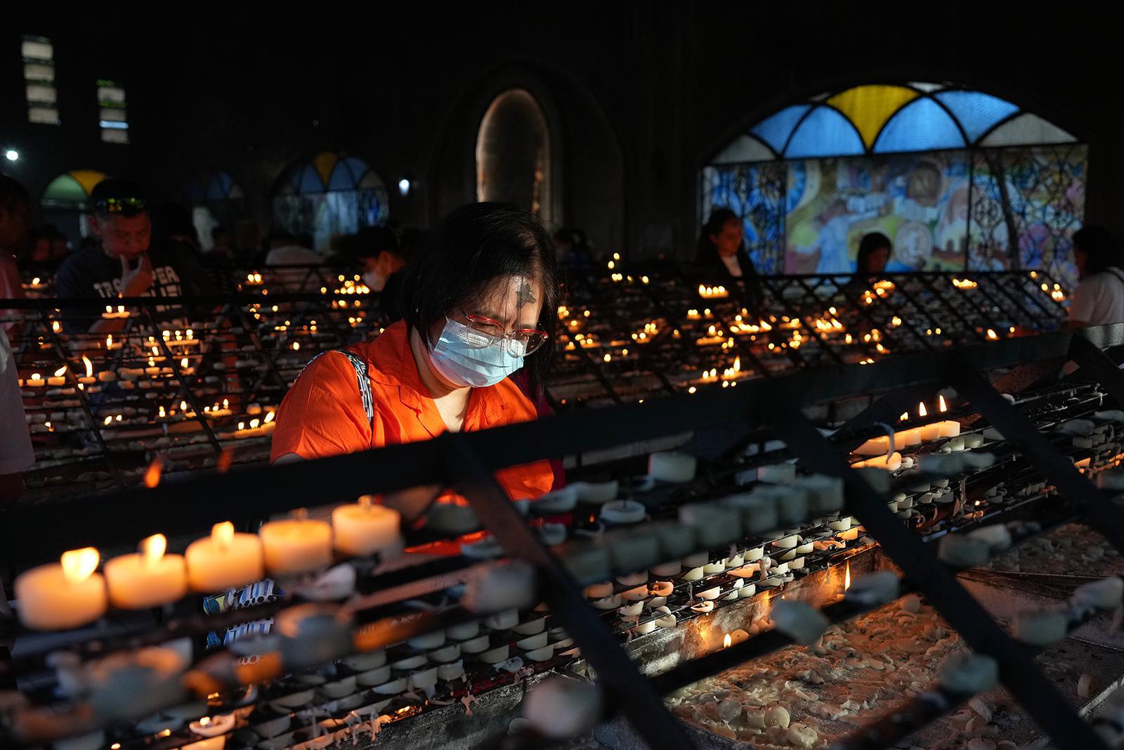  تُشعل إحدى المتعبدات، التي تحمل صليبًا من الرماد على جبينها، الشموع خلال طقوس أربعاء الرماد يوم الأربعاء ١٨ فبراير ٢٠٢٦، في كنيسة الفادي الأقدس في مانيلا، الفلبين، حيث يحتفل الكاثوليك في هذه الدولة ذات الأغلبية الكاثوليكية الرومانية ببداية الصوم الكبير. (صورة من وكالة أسوشيتد برس/آرون فافيلا) 