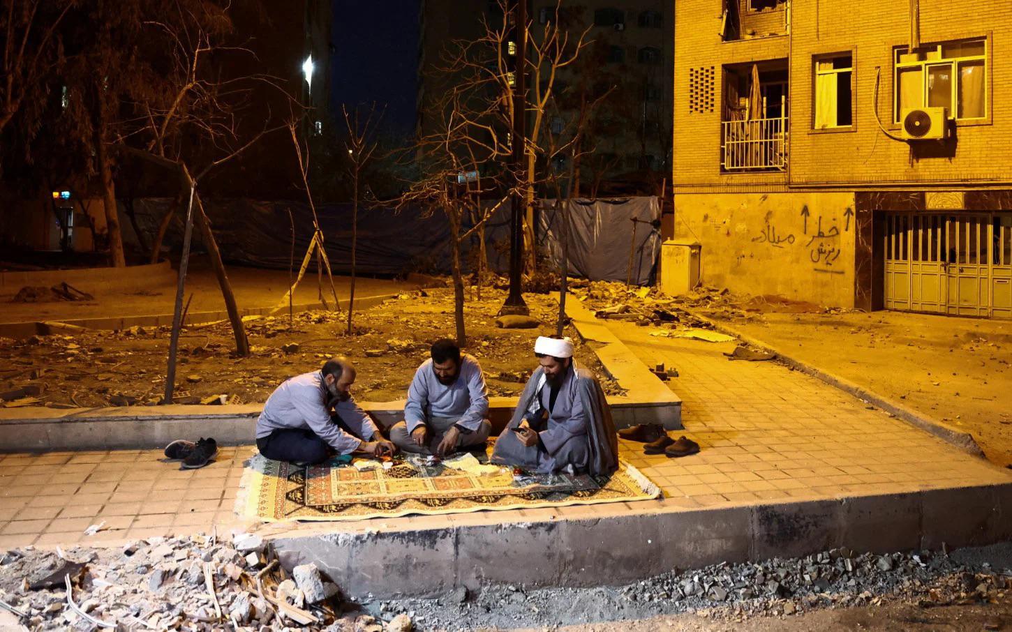 في إيران، سيحيي المسلمون عيد الفطر يوم السبت؛ وتُظهر هذه الصورة الملتقطة في 18 مارس/آذار 2026 فريقًا من المتطوعين يجلسون لمائدة الإفطار في طهران، وهو فريق يساعد الأهالي في تنظيف منازلهم وإصلاحها بعد الضربات الجوية الأمريكية‑الإسرائيلية.
