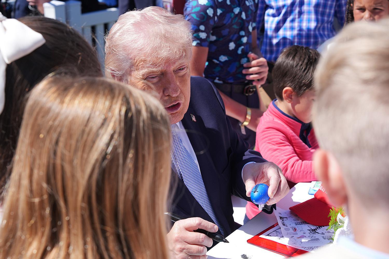 يجلس الرئيس دونالد ترامب مع الأطفال أثناء مشاركته في فعالية دحرجة بيض عيد الفصح في البيت الأبيض، في الحديقة الجنوبية للبيت الأبيض، يوم الاثنين 6 أبريل/نيسان 2026، في واشنطن. (صورة من وكالة أسوشيتد برس/أليكس براندون) 