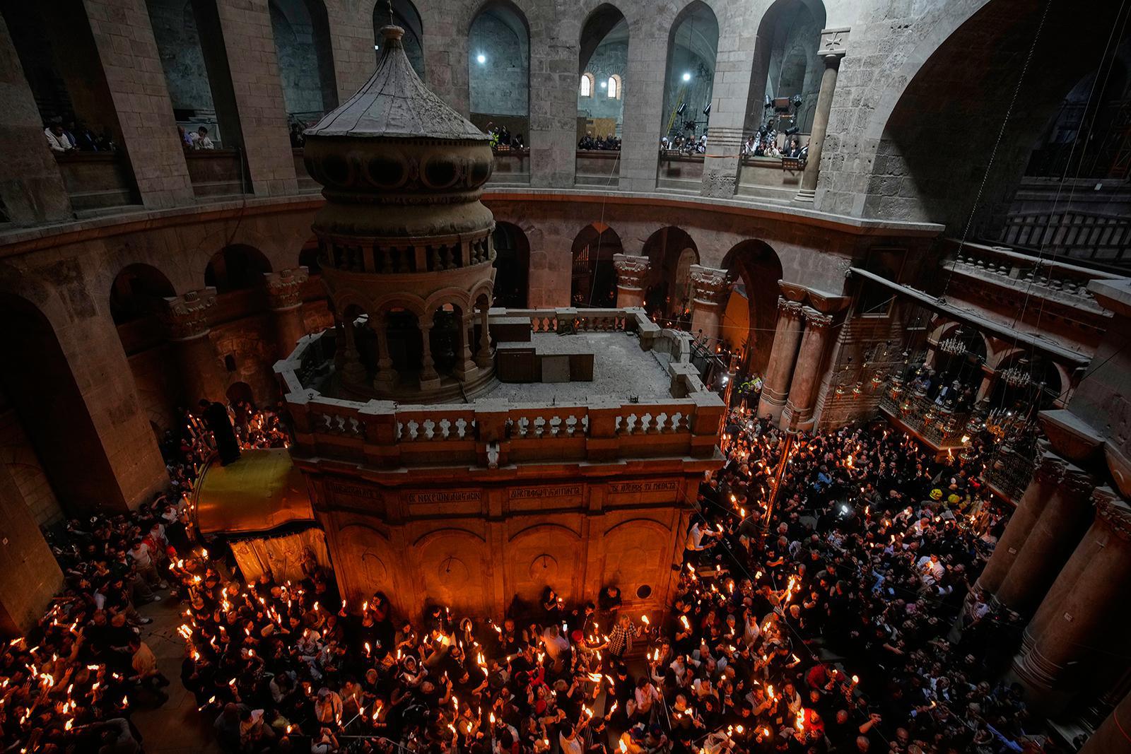 يرفع الحجاج المسيحيون الأرثوذكس الشموع خلال مراسم إشعال النار المقدسة في كنيسة القيامة، الموقع الذي يُعتقد، وفقًا للتقاليد، أن السيد المسيح صُلب ودُفن فيه، في البلدة القديمة بالقدس، يوم السبت 11 أبريل/نيسان 2026. (صورة من وكالة أسوشيتد برس/أوهاد زويجنبرغ). 