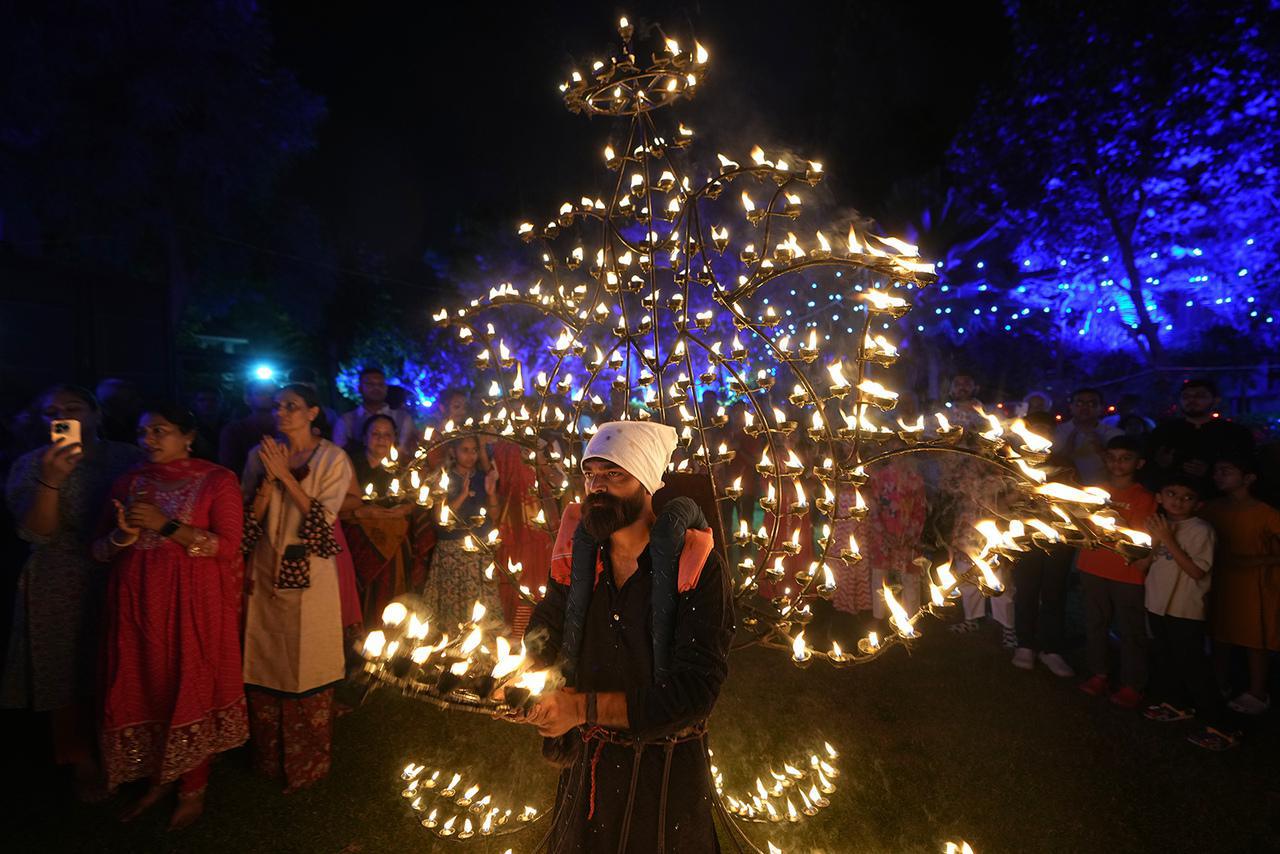 رجل يؤدي طقوس "آرتي" مرتدياً زياً تقليدياً مزيناً بمصابيح الزيت خلال الليلة الخامسة من مهرجان "نافاراتري"، احتفال التسع ليالٍ، في أحمد Le 26 janvier 2025. (صورة لوكالة أسوشيتد برس/أجيت سولانكي)