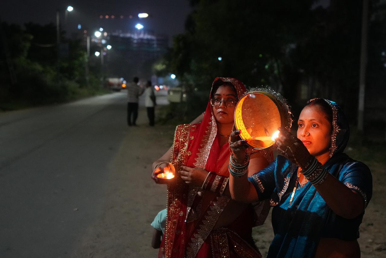 تنظر امرأة هندوسية متزوجة إلى القمر من خلال غربال كجزء من طقس لكسر صيامها خلال مهرجان كارفا تشوث، في أحمد آباد، الهند، الجمعة، 10 أكتوبر 2025. (أ ب/أجيت سولانكي)