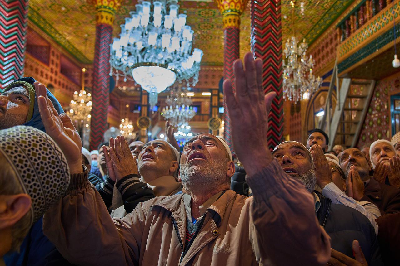 يصلي المسلمون الكشميريون بينما يعرض رجل دين أثرًا للقديس الصوفي الشيخ سيد عبد القادر الجيلاني داخل ضريحه في سريناغار، كشمير التي تسيطر عليها الهند، الجمعة، 10 أكتوبر 2025. (أ ب/دار ياسين)