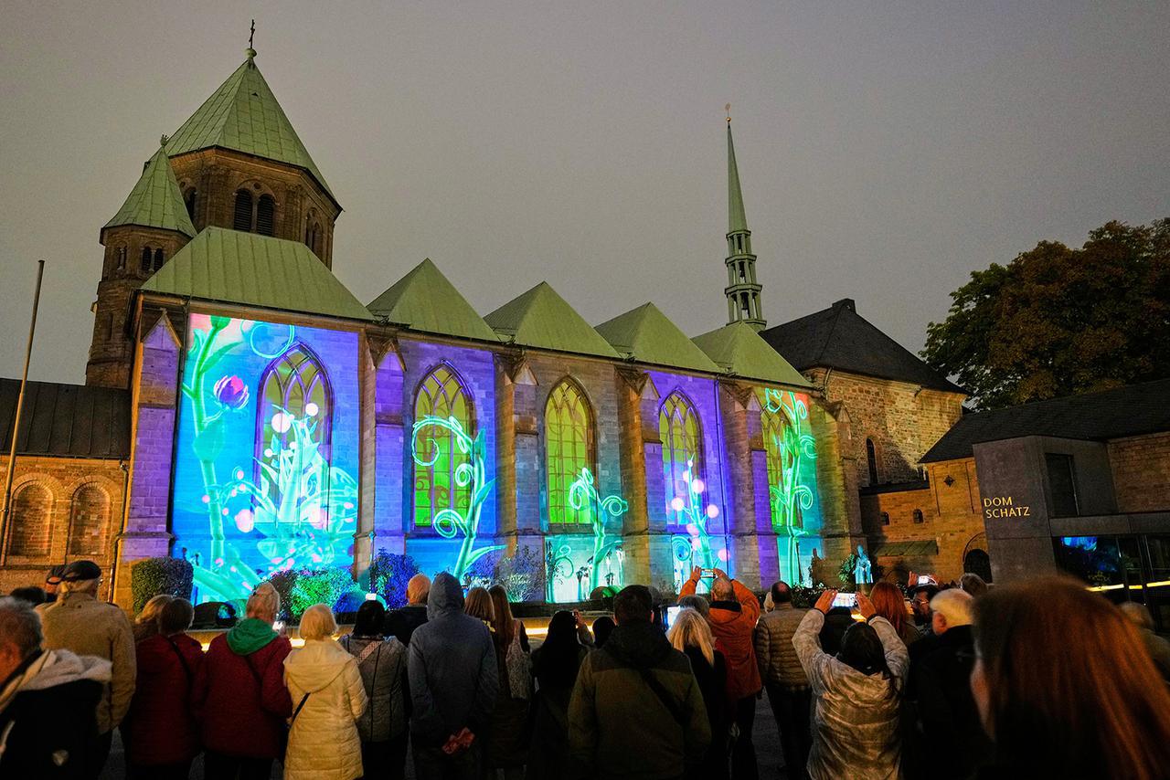 يشاهد الناس عرضًا فنيًا ضوئيًا على الكاتدرائية الكاثوليكية خلال مهرجان إيسن الضوئي في وسط مدينة إيسن، ألمانيا، الأربعاء، 8 أكتوبر 2025. (أ ب/مارتن مايسنر)