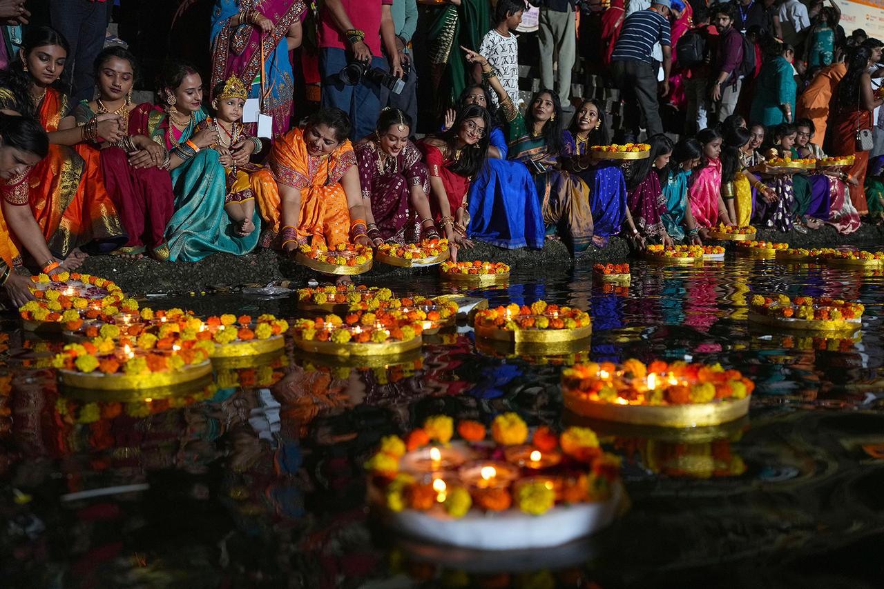 نساء هندوسيات يشعلن مصابيح زيتية عند بركة بانغانغا خلال احتفال ديف ديبافالي في مومباي، الهند، يوم الأربعاء