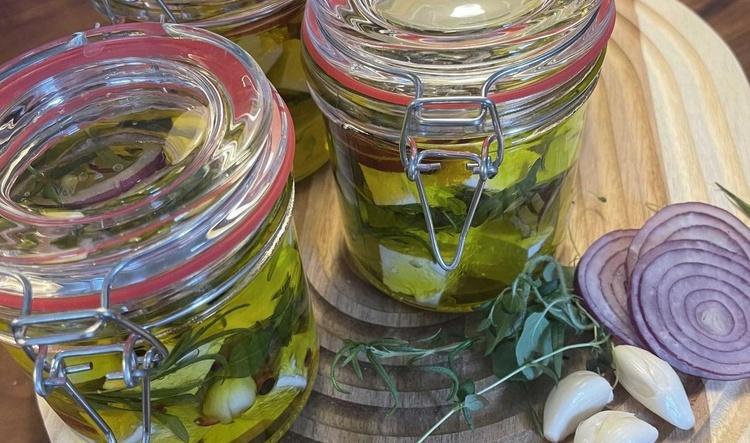 Feta eingelegt mit frischen Kräutern in Olivenöl.