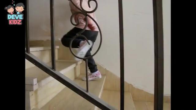 يصعد على الدرج بتبادل القدمين مع مسك مساعدة